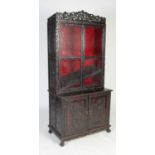 A Chinese dark wood display cabinet/ bookcase, late 19th/ early 20th century, the upper section with