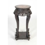 A Chinese dark wood urn stand, Qing Dynasty, the circular top with mottled purple and white marble