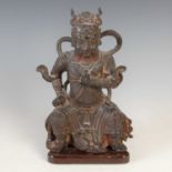 A Chinese bronze figure of Wudi, modelled sitting with fierce expression and flying scarves, on