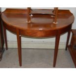 A mahogany demilune console table with raised gallery back, raised on four square tapered supports.