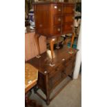 An early 20th century oak side cabinet with two long drawers above two cupboard doors, raised on