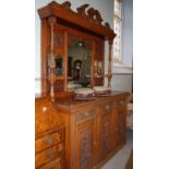 A carved oak mirror-back sideboard, the back with three bevelled glass panels and two shaped