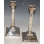 A pair of late 19th/ early 20th century London silver Corinthian column candlesticks, with