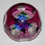 A John Deacons paperweight dated 1997, of circular faceted form enclosing a blue petalled flower