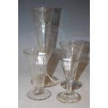 A tall 18th century drinking glass with tapered conical bowl with hammered flutes on folded
