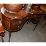 A 20th century kidney-shaped desk with brown leatherette top, three shaped drawers above two