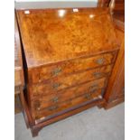 A George III style reproduction walnut bureau, the fall-front with twin brass lever-actioned