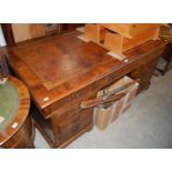 A 20th century George III style twin pedestal desk with brown leatherette top, one long drawer