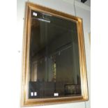 A gilt framed rectangular bevelled wall mirror.