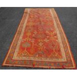 A late 19th/ early 20th century madder ground Ushak long rug, the rectangular field worked in green,