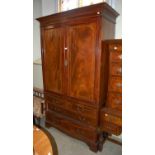 An Edwardian mahogany linen press, the upper section with two cupboard doors opening to an