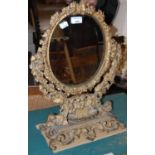 A gilt dressing table mirror, the oval glass mirror plate with floral border.