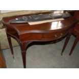 An Edwardian mahogany serpentine fronted games table, the flip-top opening to green leatherette