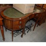 An Edwardian mahogany kidney-shaped desk with green leatherette top, three shaped drawers above