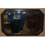 An early 20th century oak framed octagonal bevelled wall mirror, 77cm wide, together with a late