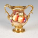 A hand-painted Coalport twin-handled urn, decorated with fruit on a mossy background within richly