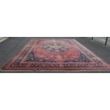 An early to mid-20th century Persian carpet, the rectangular madder ground centred with a large blue