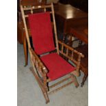 A 20th century rocking chair with turned details and red upholstery