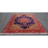 A 20th century Persian rug, the rectangular blue ground centred with a large madder medallion on a