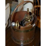 A riveted copper fuel bin containing assorted fireside accessories