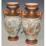 A pair of late 19th/ early 20th century Japanese porcelain Kutani vases decorated with panels of