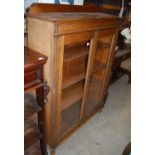 An early 20th century oak glazed two-door bookcase