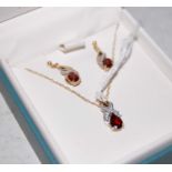 A 9ct gold diamond chip and garnet set pendant and chain together with a pair of matching earrings