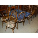 A vintage Ercol dining room suite comprising table, sideboard and eight spindle back chairs