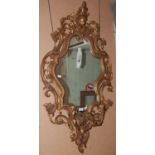 A late 19th/ early 20th century Rococo style gilt wood girandole wall mirror, the shaped mirror