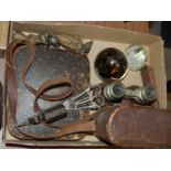 A box of mixed wares comprising two glass paperweights, a cased set of binoculars, a set of opera