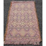 A 20th century rug, the blue-purple ground woven in orange, green and black coloured threads with