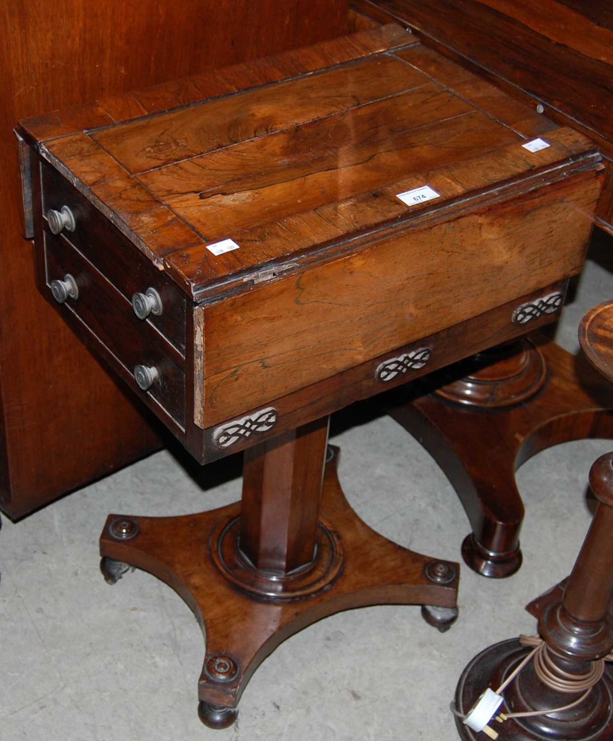 A 19th century rosewood work table on octagonal column and concave platform base with four bun feet