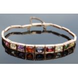 A yellow metal and multi-gem set bracelet, set with nine various rectangular cushion faceted