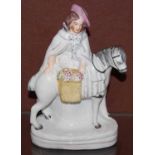 A 19th century Staffordshire figure of lady on horseback with basket of fruit
