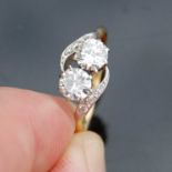 A mid-20th century yellow and white metal two stone diamond ring with diamond set shoulders, set