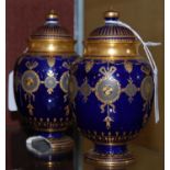 A pair of Crown Derby cobalt blue ground miniature jars and covers with richly gilded Neo-