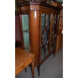 An Edwardian mahogany and satinwood banded display cabinet with two glazed cupboard doors opening to