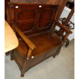An early 20th century stained oak monks bench with hinged seat