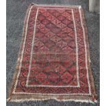 A Persian rug, early 20th century, the abrashed madder ground decorated with angular rows of
