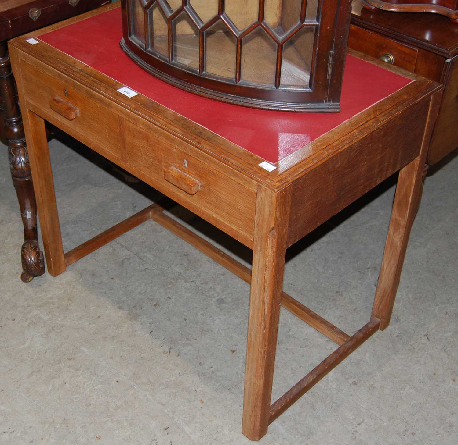 An early 20th century Art Deco style oak side table/ writing desk with red leatherette insert top