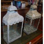 A pair of antique style metal and glass wall lanterns