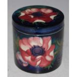 A Moorcroft pottery blue ground jar and cover, decorated with anemones, 9cm high, stamped marks,