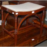 An early 20th century mahogany dressing table stool with concave upholstered seat