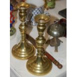 Two brass candlesticks, a mixed metal table bell and a brass knife