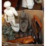 A box containing various composite figures, vintage photo frames, brass rattle etc