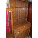 A 20th century oak dresser, the top section with three shelves, the lower section with long drawer