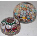 A colourful millefiori ground paperweight, together with another similar smaller paperweight
