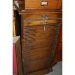 A vintage oak stationery cabinet with tambour shutter, opening to a fitted interior with nine