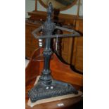 A vintage black painted cast metal corner stick stand, with flame finial, 65cm high