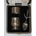 A cased Birmingham silver three-piece egg cup, napkin ring and spoon set